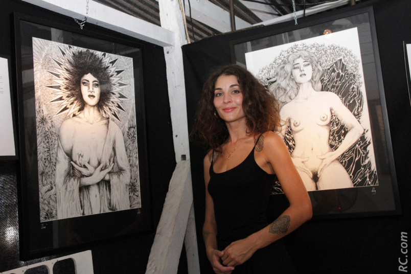 Belly, illustratrice, devant deux de ses oeuvres Belly, illustratrice, devant deux de ses oeuvres