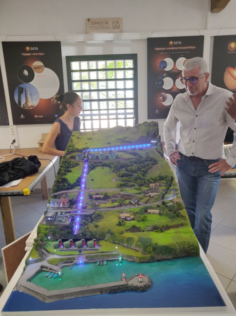 James Caratini, directeur de Sciences Réunion, devant la maquette représentant la centrale Hydroélectrique de la Rivière de l’Est