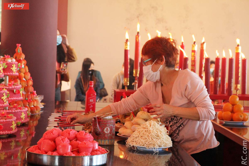 Une bénévole qui participe à la mise en place des offrandes Une bénévole qui participe à la mise en place des offrandes