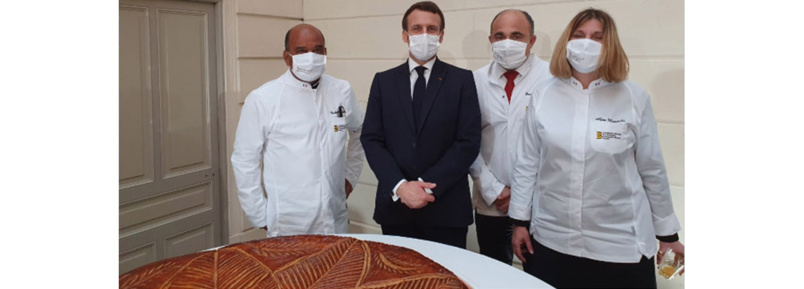 Norbert Tacoun (à gauche) aux côtés d'Emmanuel Macron devant l'énorme galette de l'Epiphanie de l'Elysée Norbert Tacoun (à gauche) aux côtés d'Emmanuel Macron devant l'énorme galette de l'Epiphanie de l'Elysée