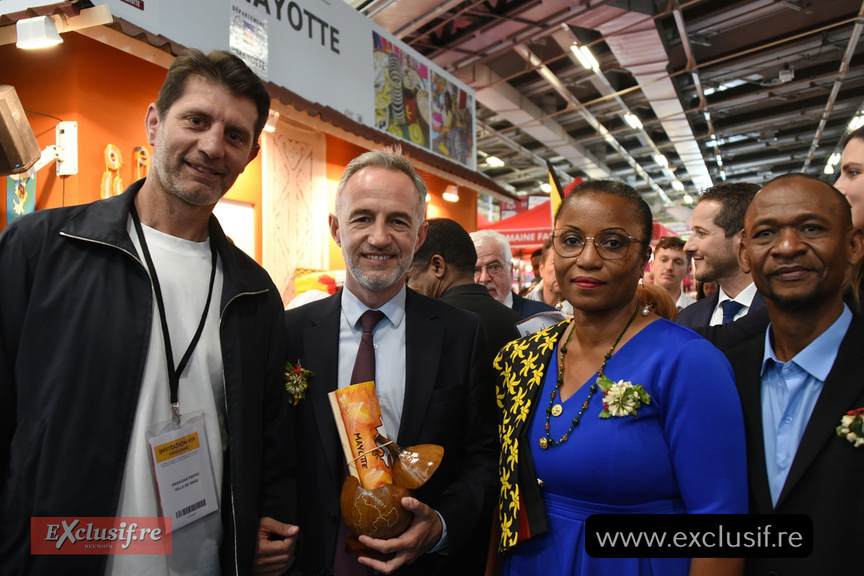 Accueil fleuri et cadeau au stand de Mayotte pour Emmanuel Grégoire. A gauche Pierre Rabadan, président de "Paris Je t'aime", et à droite, Laurent Sorel, adjoint au maire, chargé des Outre-mer