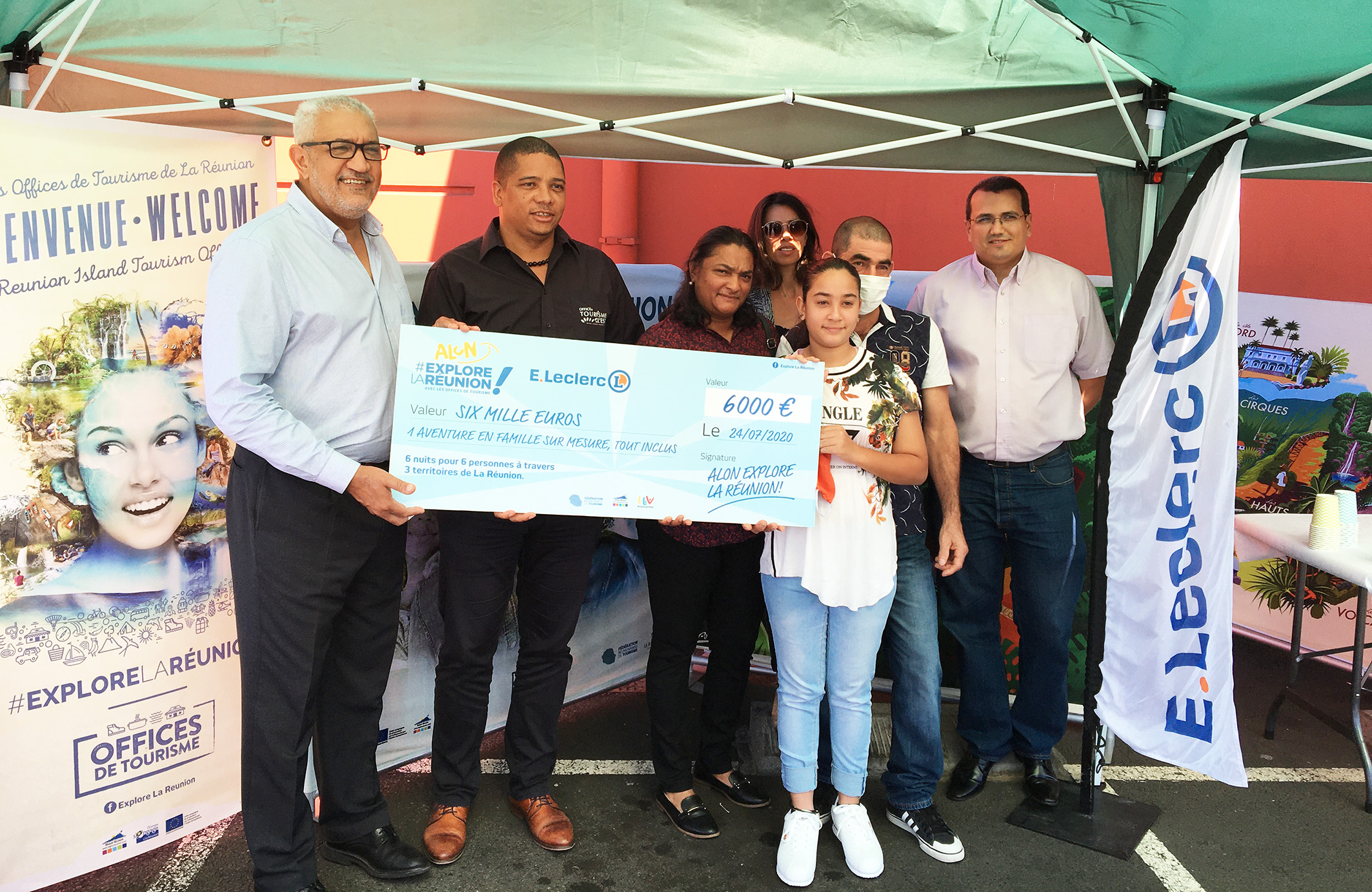 Azeddine Bouali, président de la FRT, Louis, directeur de l'OTI Est, Mme Payet, directrice marketing Leclerc, et le directeur de Leclerc Express Saint-Benoît, remettent un lot d’une valeur de 6 000 euros à Jean-Louis P., entourée de sa famille